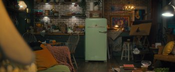 Movie still from “Puppy Love” (2023), directed by Richard Alan Reid – An old fashioned refrigerator in the middle of a kitchen; Extreme Wide shot, High angle