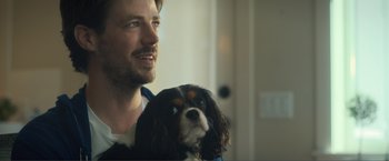 Movie still from “Puppy Love” (2023), directed by Richard Alan Reid – A person holding a dog; Close Up shot, Low angle