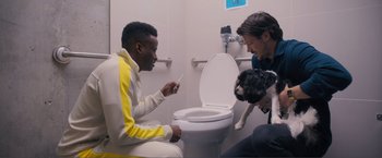 Movie still from “Puppy Love” (2023), directed by Richard Alan Reid – Two men and a dog in a bathroom with a toilet; Medium shot, Over the shoulder angle