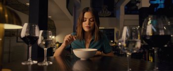 Movie still from “Puppy Love” (2023), directed by Richard Alan Reid – A woman sitting in front of a bowl of food; Medium shot, High angle