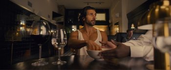 Movie still from “Puppy Love” (2023), directed by Richard Alan Reid – A man sitting at a table with a bowl of food in front of him; Medium shot, Over the shoulder angle