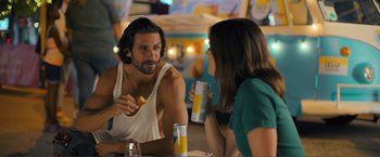 Movie still from “Puppy Love” (2023), directed by Richard Alan Reid – A man and a woman sitting at a table with drinks; Medium shot, Over the shoulder angle