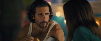 Movie still from “Puppy Love” (2023), directed by Richard Alan Reid – A man with long hair and a beard is looking at a woman; Close Up shot, Over the shoulder angle
