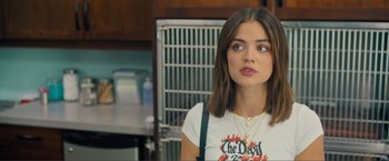 Movie still from “Puppy Love” (2023), directed by Richard Alan Reid – A woman in a white t - shirt is standing in a kitchen; Close Up shot, Over the shoulder angle