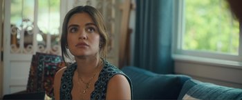 Movie still from “Puppy Love” (2023), directed by Richard Alan Reid – A beautiful young lady sitting on a couch in a room; Close Up shot, Over the shoulder angle