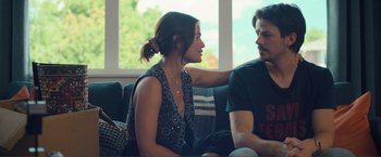 Movie still from “Puppy Love” (2023), directed by Richard Alan Reid – A man and a woman sitting on a couch talking to each other; Medium shot, Over the shoulder angle