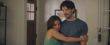 Movie still from “Puppy Love” (2023), directed by Richard Alan Reid – A man and a woman hugging in a living room; Medium shot, Over the shoulder angle