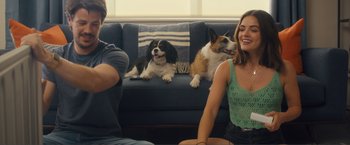 Movie still from “Puppy Love” (2023), directed by Richard Alan Reid – Two dogs sitting on a couch next to two people; Medium shot, Over the shoulder angle