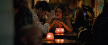 Movie still from “Puppy Love” (2023), directed by Richard Alan Reid – A man and a woman sitting at a table with candles; Medium shot, Over the shoulder angle