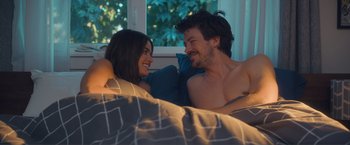 Movie still from “Puppy Love” (2023), directed by Richard Alan Reid – A man and a woman laying in a bed together; Medium shot, Over the shoulder angle