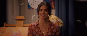 Movie still from “Puppy Love” (2023), directed by Richard Alan Reid – A woman in a floral shirt smiling for the camera; Close Up shot, Over the shoulder angle