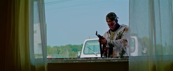 Movie still from “Pursuit” (2022), directed by Brian Skiba – A man working on a white pickup truck; Medium shot, Low angle