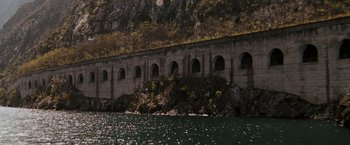 Movie still from “Quantum of Solace” (2008), directed by Marc Forster – A view of a lake with a bridge in the middle of it; Extreme Wide shot, High angle