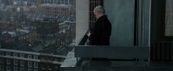Movie still from “Quantum of Solace” (2008), directed by Marc Forster – An older man is standing on a balcony looking out the window; Wide shot, High angle