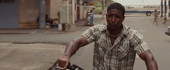 Movie still from “Quantum of Solace” (2008), directed by Marc Forster – A man riding a bicycle down a street; Close Up shot, High angle