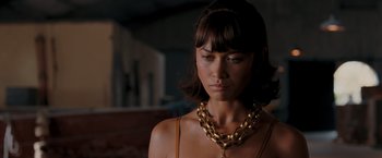 Movie still from “Quantum of Solace” (2008), directed by Marc Forster – A woman wearing a gold chain around her neck; Close Up shot, Over the shoulder angle