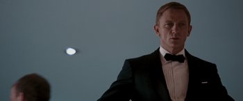 Movie still from “Quantum of Solace” (2008), directed by Marc Forster – A person wearing a suit and tie; Medium shot, Low angle