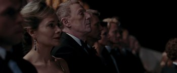 Movie still from “Quantum of Solace” (2008), directed by Marc Forster – A group of people standing in front of each other; Close Up shot, Over the shoulder angle