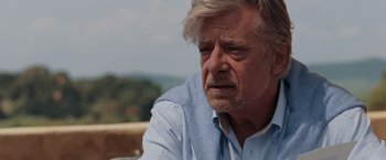 Movie still from “Quantum of Solace” (2008), directed by Marc Forster – An older man wearing a light blue shirt; Close Up shot, Over the shoulder angle
