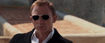 Movie still from “Quantum of Solace” (2008), directed by Marc Forster – A person wearing sunglasses; Close Up shot, Over the shoulder angle
