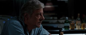 Movie still from “Quantum of Solace” (2008), directed by Marc Forster – An older man sitting in front of a window; Close Up shot, Over the shoulder angle