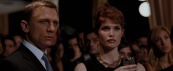 Movie still from “Quantum of Solace” (2008), directed by Marc Forster – A man and a woman standing next to each other in a crowd; Close Up shot, Low angle
