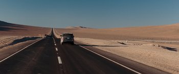 Movie still from “Quantum of Solace” (2008), directed by Marc Forster – A car driving down a road in the middle of the desert; Extreme Wide shot, High angle
