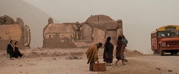 Movie still from “Quantum of Solace” (2008), directed by Marc Forster – A group of people walking across a dirt field; Wide shot, Low angle