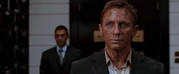 Movie still from “Quantum of Solace” (2008), directed by Marc Forster – A man in a suit and tie standing next to another man in a suit and tie; Close Up shot, Low angle