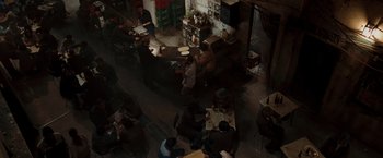 Movie still from “Quantum of Solace” (2008), directed by Marc Forster – People are sitting at tables in an open air restaurant; Extreme Wide shot, High angle