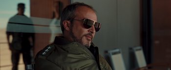 Movie still from “Quantum of Solace” (2008), directed by Marc Forster – A person wearing sunglasses and a jacket; Close Up shot, Low angle