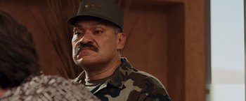 Movie still from “Quantum of Solace” (2008), directed by Marc Forster – A man in a military uniform is looking at the camera; Close Up shot, Low angle