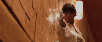 Movie still from “Quantum of Solace” (2008), directed by Marc Forster – A woman is pointing at a brick wall; Close Up shot, Low angle