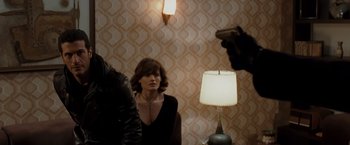 Movie still from “Quantum of Solace” (2008), directed by Marc Forster – A woman sitting in front of a man with a camera; Medium shot, Over the shoulder angle