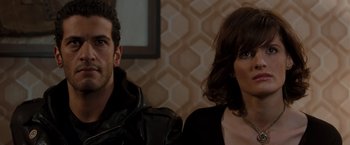 Movie still from “Quantum of Solace” (2008), directed by Marc Forster – A man and a woman sitting next to each other; Close Up shot, Over the shoulder angle