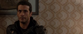 Movie still from “Quantum of Solace” (2008), directed by Marc Forster – A person wearing a leather jacket; Close Up shot, Over the shoulder angle