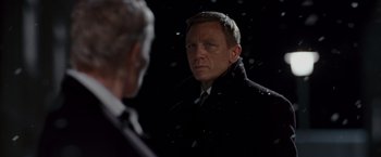 Movie still from “Quantum of Solace” (2008), directed by Marc Forster – A man in a black coat looking at himself in the mirror; Close Up shot, Over the shoulder angle