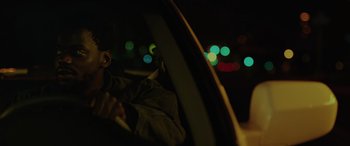 Movie still from “Queen & Slim” (2019), directed by Melina Matsoukas – A person sitting in the driver's seat of a car at night; Close Up shot, Over the shoulder angle