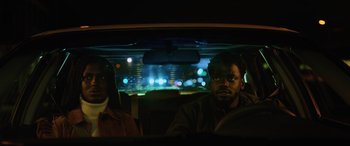 Movie still from “Queen & Slim” (2019), directed by Melina Matsoukas – Two people in a car at night with lights in the background; Medium shot, Over the shoulder angle