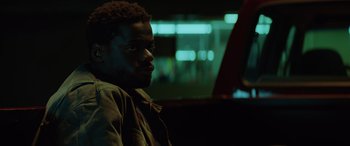 Movie still from “Queen & Slim” (2019), directed by Melina Matsoukas – A man sitting in the back of a car at night; Close Up shot, Low angle