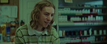 Movie still from “Queen & Slim” (2019), directed by Melina Matsoukas – A person sitting in a room next to a shelf; Close Up shot, Over the shoulder angle