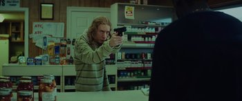 Movie still from “Queen & Slim” (2019), directed by Melina Matsoukas – A man holding a gun in a store; Medium shot, Low angle