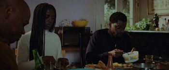 Movie still from “Queen & Slim” (2019), directed by Melina Matsoukas – Two people sitting at a table eating food; Medium shot, Over the shoulder angle