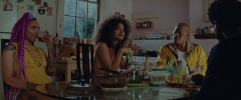 Movie still from “Queen & Slim” (2019), directed by Melina Matsoukas – A woman sitting at a table with a bowl of food in front of her; Medium shot, Low angle