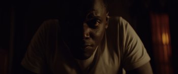 Movie still from “Queen & Slim” (2019), directed by Melina Matsoukas – A person's face in a dark room; Close Up shot, Low angle