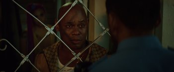 Movie still from “Queen & Slim” (2019), directed by Melina Matsoukas – A man looking at another man through a fence; Close Up shot, Over the shoulder angle