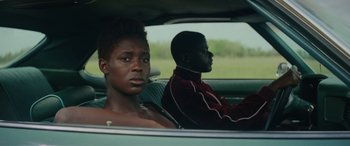 Movie still from “Queen & Slim” (2019), directed by Melina Matsoukas – A woman and a man sitting in the back seat of a car; Close Up shot, Over the shoulder angle
