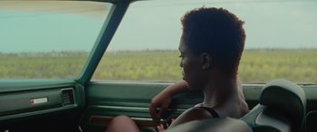 Movie still from “Queen & Slim” (2019), directed by Melina Matsoukas – A woman sitting in the passenger seat of a green car; Close Up shot, Over the shoulder angle