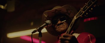 Movie still from “Queen & Slim” (2019), directed by Melina Matsoukas – An older man wearing a cowboy hat holding a guitar; Close Up shot, Low angle