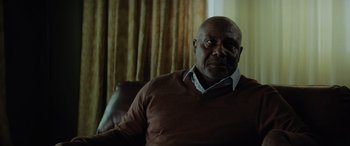 Movie still from “Queen & Slim” (2019), directed by Melina Matsoukas – An older man sitting in a chair in front of a window; Close Up shot, Low angle